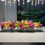 Moderne Hausvase aus Glas mit rosa Vanda-Orchideen und grünen Cymbidien