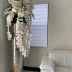 Kaskadierende Phalaenopsis-Orchideen in extra hoher, gehämmertem Vase