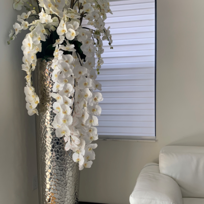 Kaskadierende Phalaenopsis-Orchideen in extra hoher, gehämmertem Vase